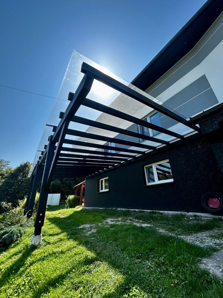 Zadaszenie tarasu wykonane z drewna litego, pokryte poliwęglanem litym 6mm wykonane przez firmę Customowe Drewno